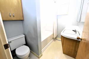 Bathroom featuring vanity, light floors, and washtub / shower combination