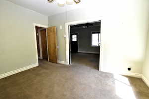 Carpeted spare room with baseboards and ceiling fan