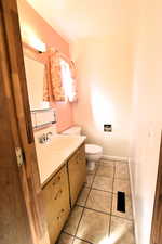 Half bathroom featuring light tile patterned flooring and vanity