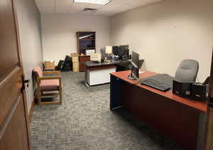 Office area featuring a drop ceiling and carpet flooring