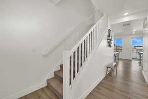 Stairway featuring wood finished floors and recessed lighting