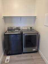 Washroom featuring separate washer and dryer and light wood-style floors
