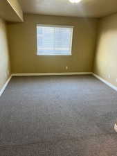 Carpeted empty room featuring a textured ceiling