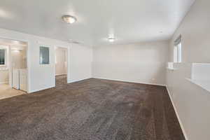 Unfurnished room featuring carpet, washer / clothes dryer, and electric panel