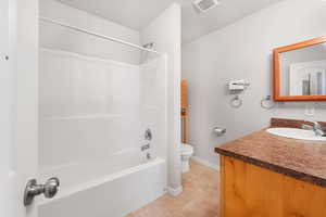Full bathroom with bathtub / shower combination, vanity, and light tile patterned flooring