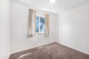 Carpeted spare room with baseboards