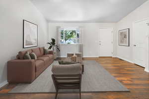 Living room featuring dark wood-style flooring and lofted ceiling