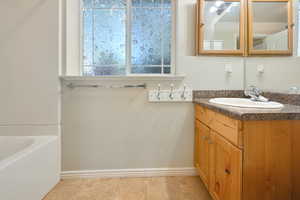 Bathroom featuring vanity and a garden tub