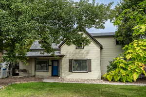 View of front of house featuring a shingled roof and covered porch