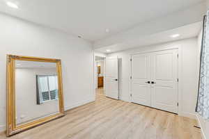 Unfurnished bedroom with recessed lighting, light wood-type flooring, and a closet