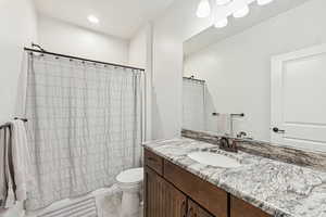 Full bath featuring vanity, shower / tub combo with curtain, and recessed lighting