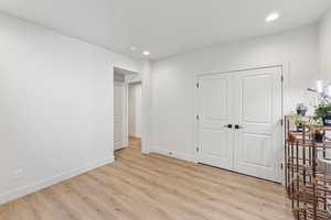 Unfurnished bedroom with recessed lighting, light wood-style floors, and a closet