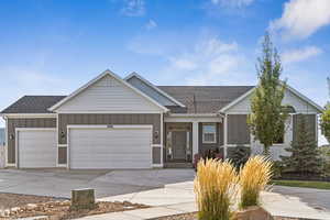 Single story home with roof with shingles, board and batten siding, concrete driveway, and an attached garage