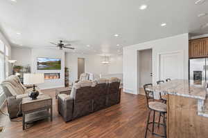 Living area featuring recessed lighting, dark wood-type flooring, a glass covered fireplace, a textured ceiling, and a ceiling fan