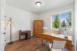 Home office with dark wood-style flooring and a textured ceiling