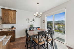 Dining area featuring dark wood-type flooring, a mountain view, a chandelier, and a textured ceiling