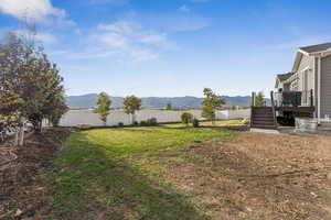 Fenced backyard with a deck with mountain view and stairs