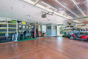 Garage with baseboards and a garage door opener