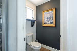Bathroom featuring toilet and wood finished floors