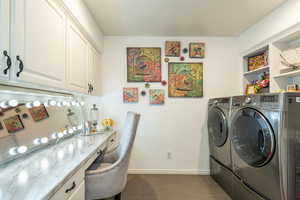 Laundry room with an office area, washer and dryer, and dark tile patterned floors