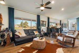 Living area featuring wood-type flooring, a ceiling fan, recessed lighting, and lofted ceiling