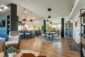 Dining area featuring lofted ceiling, light wood-type flooring, and recessed lighting