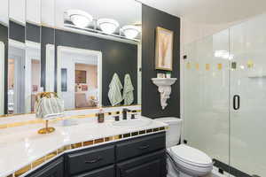 Bathroom with a shower stall, vanity, and connected bathroom