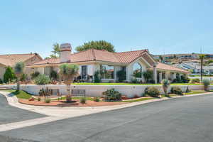 Mediterranean / spanish home featuring a tiled roof, a chimney, and stucco siding