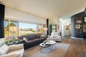 Living area with wood finished floors and lofted ceiling
