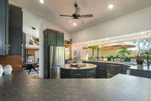 Kitchen featuring vaulted ceiling, freestanding refrigerator, recessed lighting, a ceiling fan, and a sunroom