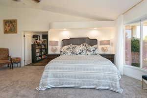 Bedroom with vaulted ceiling and carpet floors