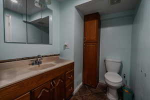 Bathroom featuring vanity and dark tile patterned floors