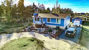 View of front of home featuring stairway and gravel driveway