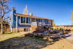 Rear view of property featuring a chimney, a wooden deck, and board and batten siding