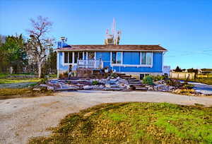 Single story home featuring covered porch, stairs, and driveway