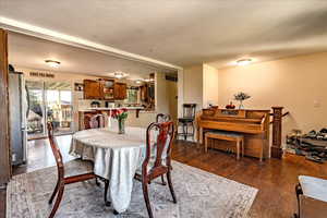 Dining space with dark wood-style floors and a textured ceiling