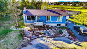 View of front of house with a deck, a shingled roof, and stairway