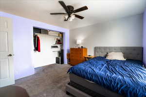 Carpeted bedroom featuring a closet and ceiling fan