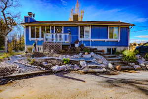 View of front of home with a chimney and a porch