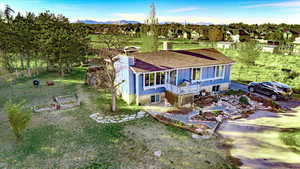 View of front facade featuring a mountain view, a view of rural / pastoral area, stairs, a front lawn, and a shingled roof
