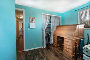 Office area with dark wood-type flooring and baseboards