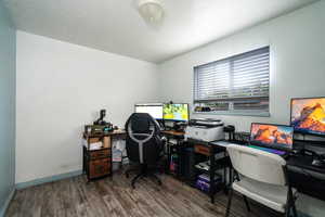 Office area with dark wood-style flooring and a textured ceiling