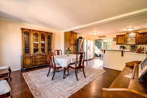 Dining room with dark wood-type flooring and crown molding