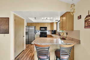 Kitchen with granite countertops a  breakfast bar.