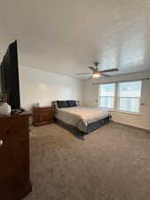 Bedroom featuring carpet, a textured ceiling, and a ceiling fan