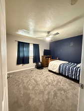 Bedroom featuring carpet floors, a textured ceiling, and a ceiling fan