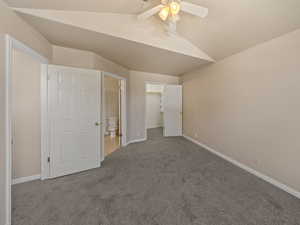 Unfurnished bedroom with carpet floors, a walk in closet, ceiling fan, and connected bathroom