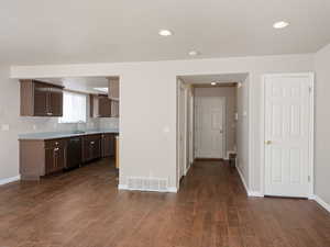 Kitchen with dark brown cabinetry, light countertops, recessed lighting, dark wood-style floors, and black dishwasher