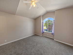 Bonus room featuring ceiling fan, carpet, vaulted ceiling, and a textured ceiling