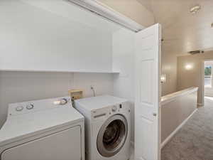 Laundry area with carpet floors and washing machine and clothes dryer